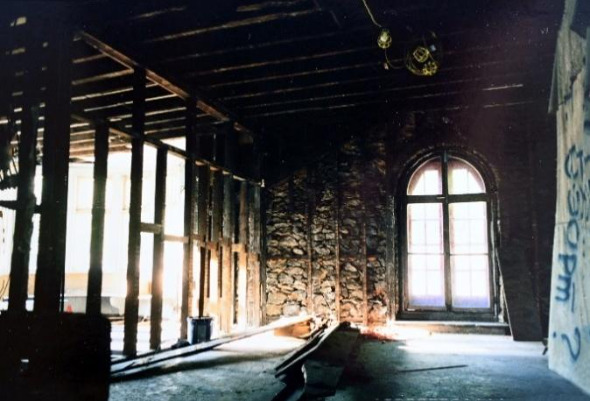 Image 11 - Round room and current kitchen and weight room gutted. The stone wall visible and arched opening is original from 1870.